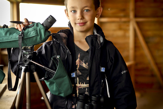 Ben in a bird hide with a telescope