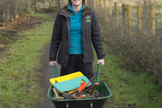 Deborah with a wheelbarrow on a nature reserve