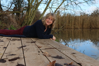 Nicky sits on the edge of a lake