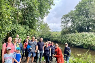 Local community volunteers smiling at the camera during an event on the River Tame at Jet Amber Fields