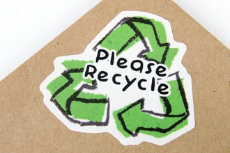 Photo of a sticker with the recycle symbol saying please recycle