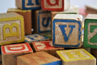 Photo of wooden toy blocks with coloured letters on
