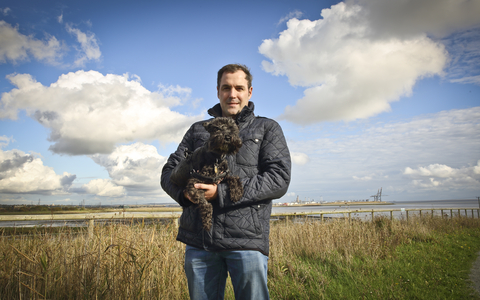 David holding his dog at a wetland