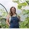 Photo of Victoria Holden, the Director of Northern Lily CIC, gardening in greenhouse.