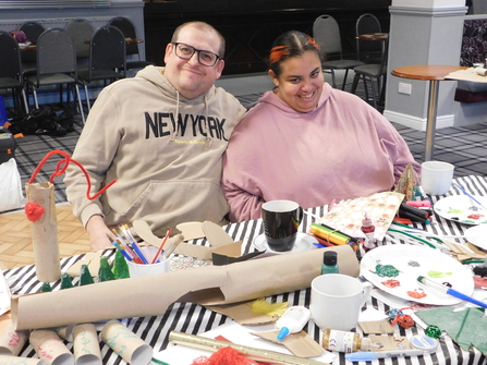 Two Green Superheroes at a recycled arts and crafts workshop
