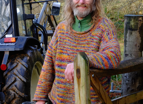 Rob standing next to a tractor holding wire