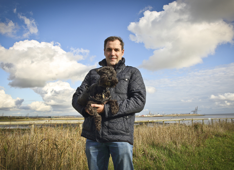 David holding his dog at a wetland