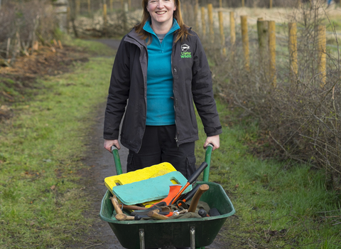 Deborah with a wheelbarrow on a nature reserve