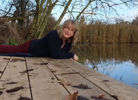 Nicky sits on the edge of a lake