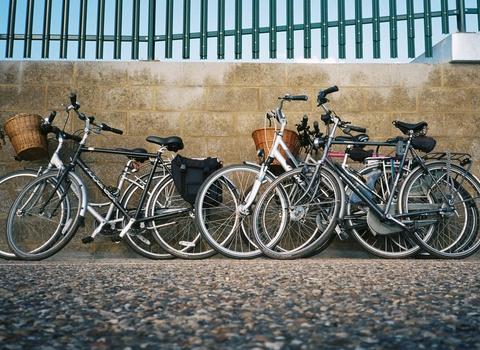 Four bikes leaning against wall