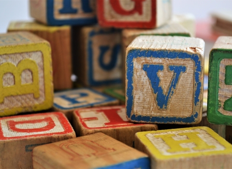 Photo of wooden toy blocks with coloured letters on